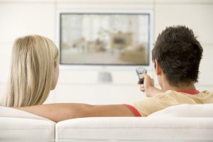 Couple in living room watching television